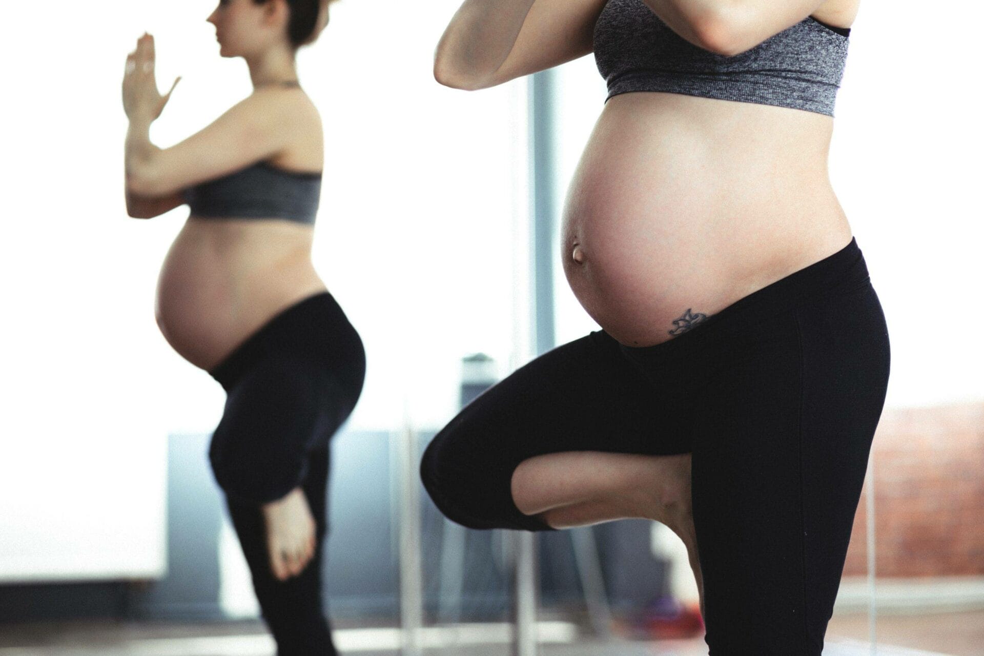 A pregnant woman doing yoga in a gym.