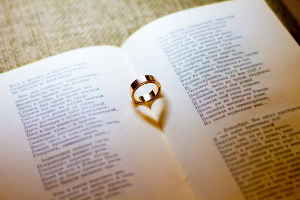 A ring sits on top of an open book.