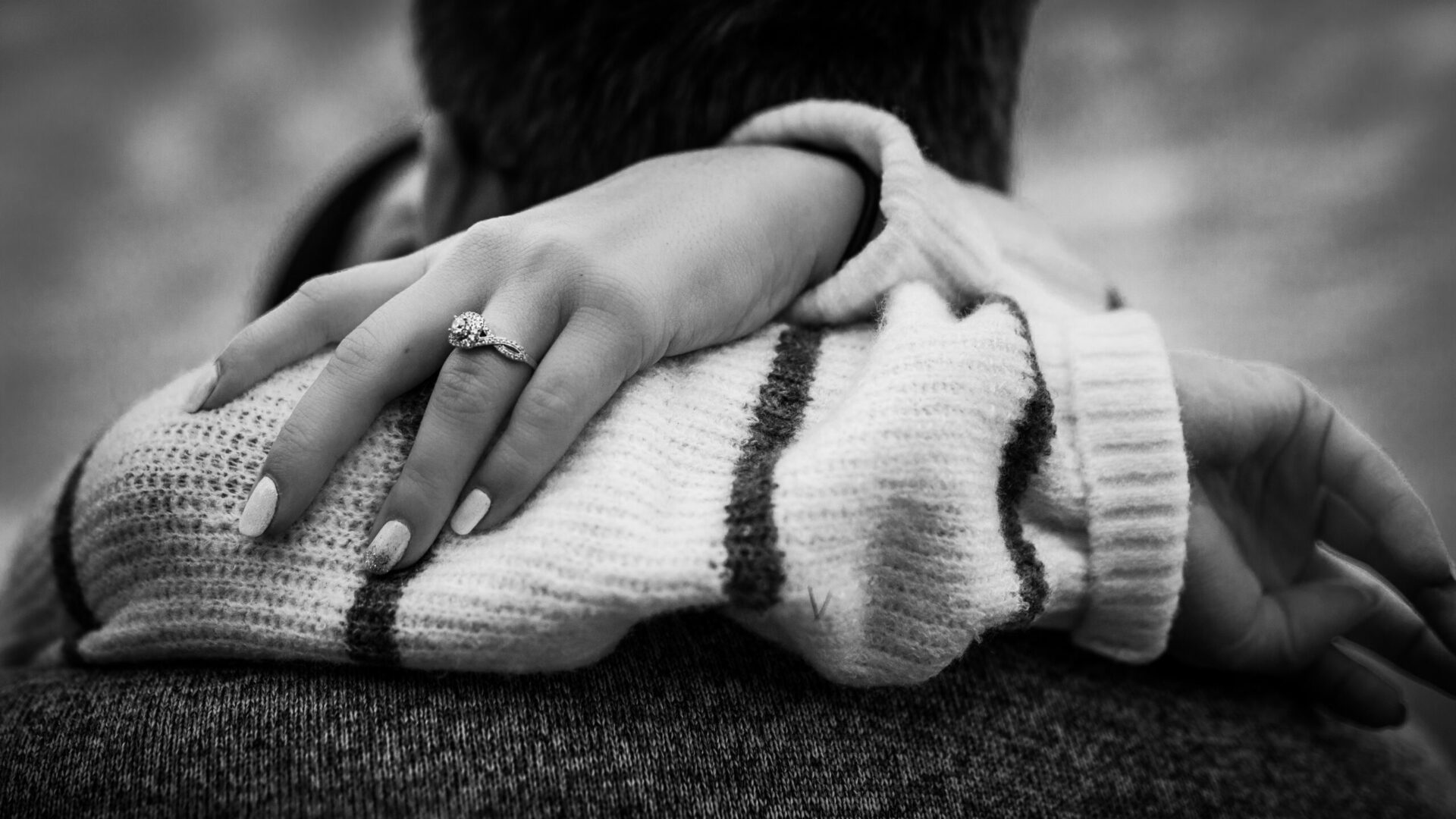 A black and white photo of a couple hugging each other.