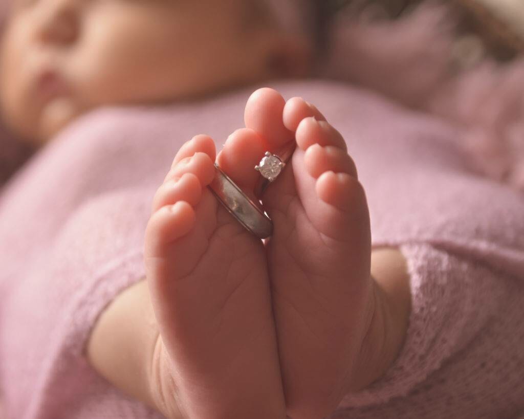 A baby's feet with a ring on them.