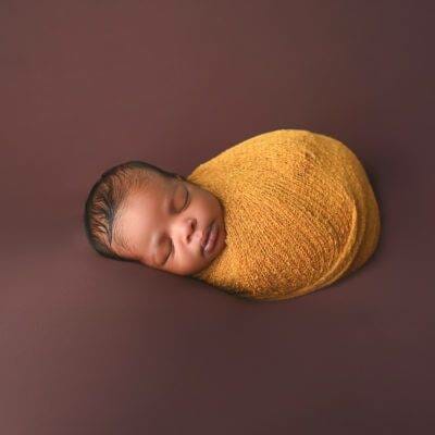 newborn in a wrap posed at Giliane E Mansfeldt Photography Studios