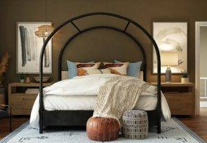 A bedroom with an arched bed and a rug.