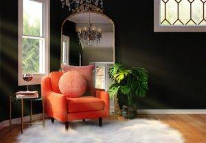 An orange chair in a room with black walls and a mirror.