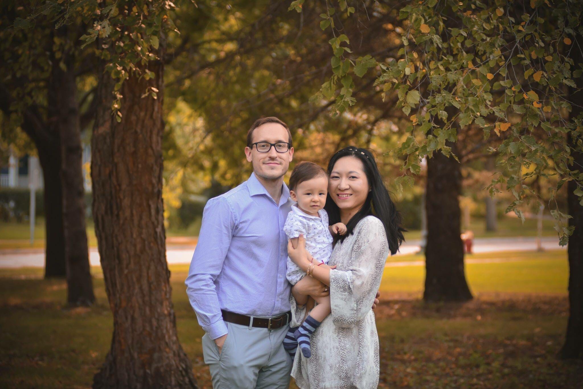 A family poses for a photo in a park.
