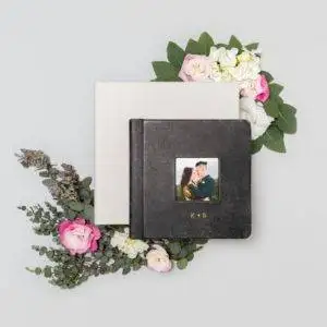 A black photo album with flowers and a photo of a couple.