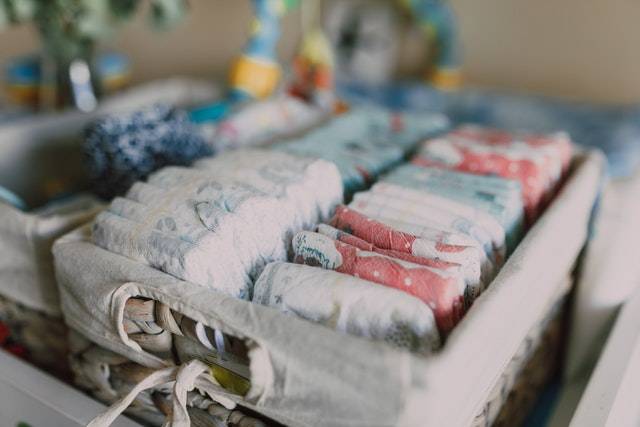 A basket full of diapers in a baby's room.