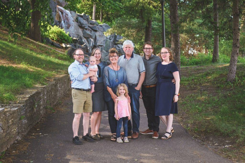 A family is posing in front of a waterfall.