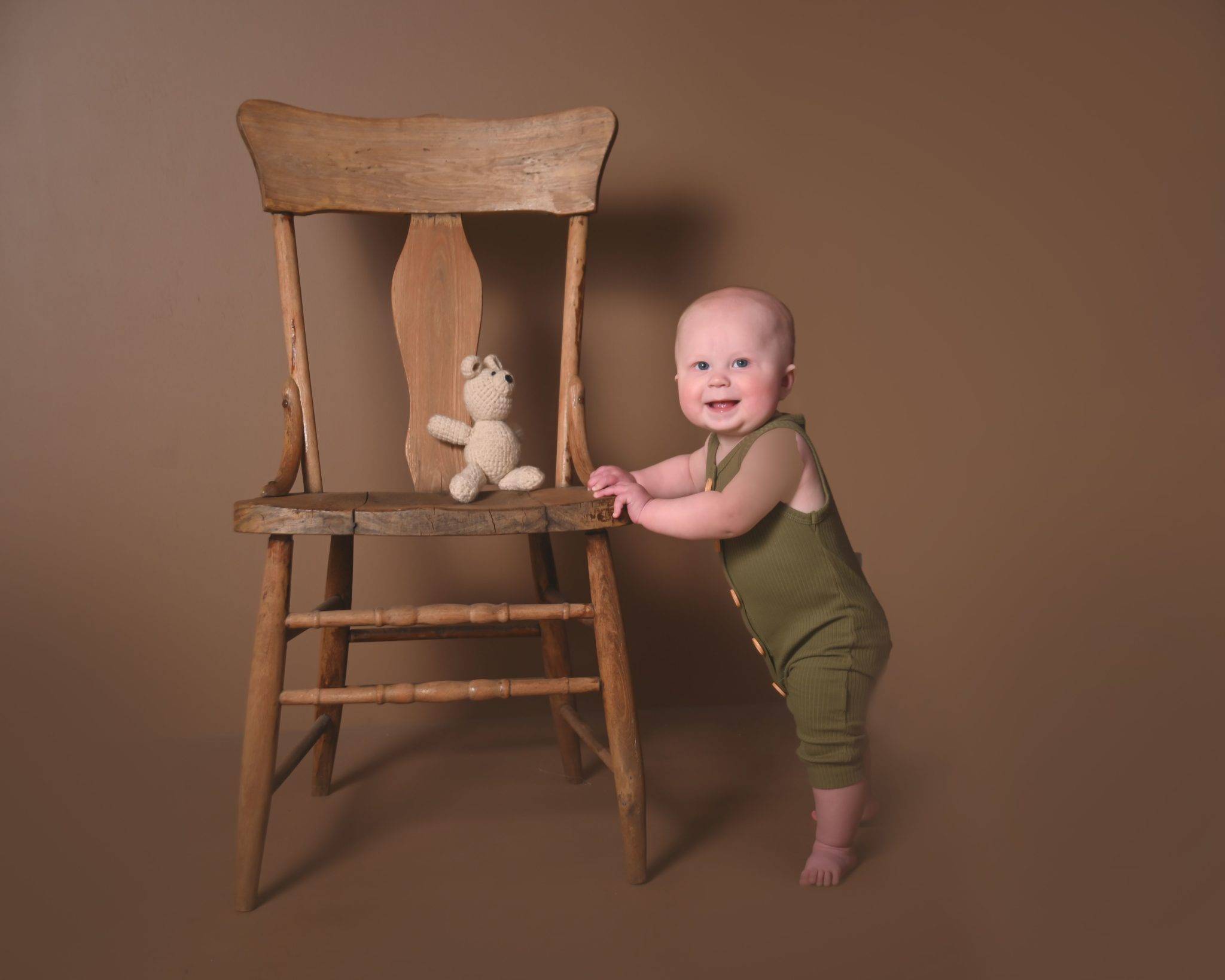 6 month photos, baby standing by chair