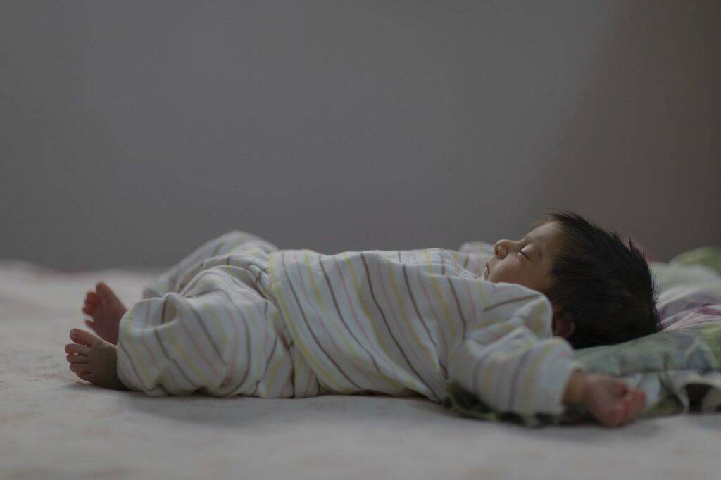 A baby laying on a bed.