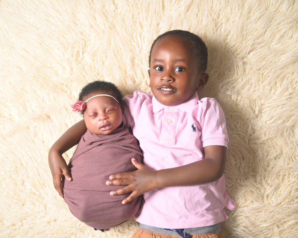 A baby boy and a baby girl laying on a fluffy blanket.