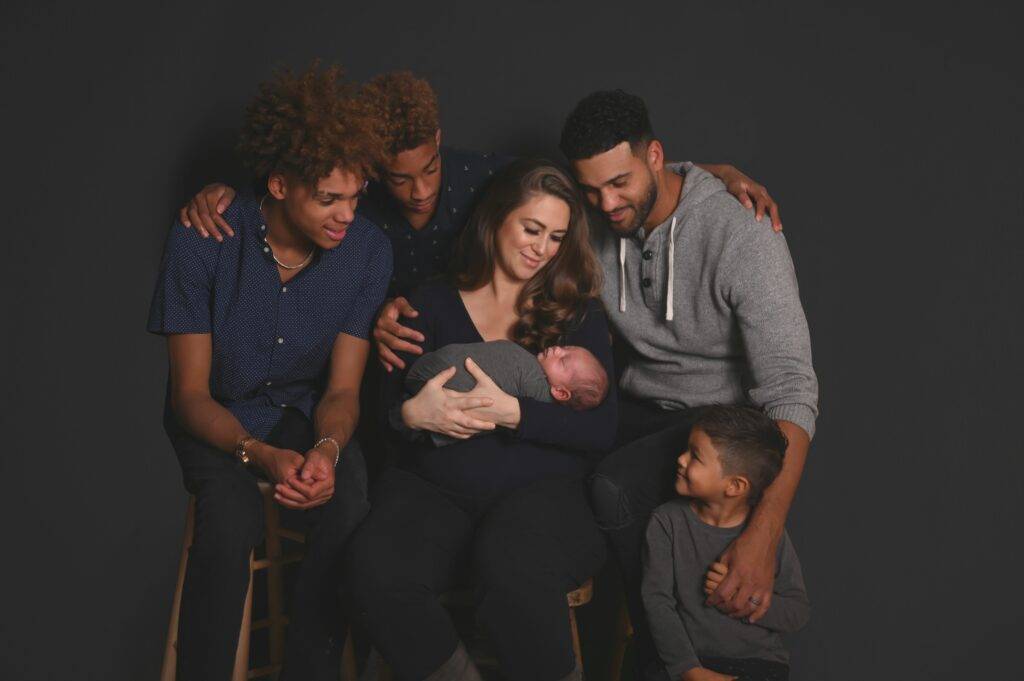 A group of people posing for a photo with a baby in their arms.