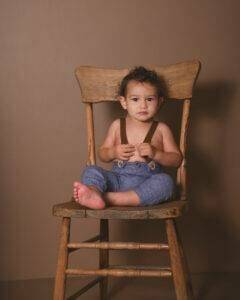 A baby sitting in a chair during a photoshoot.