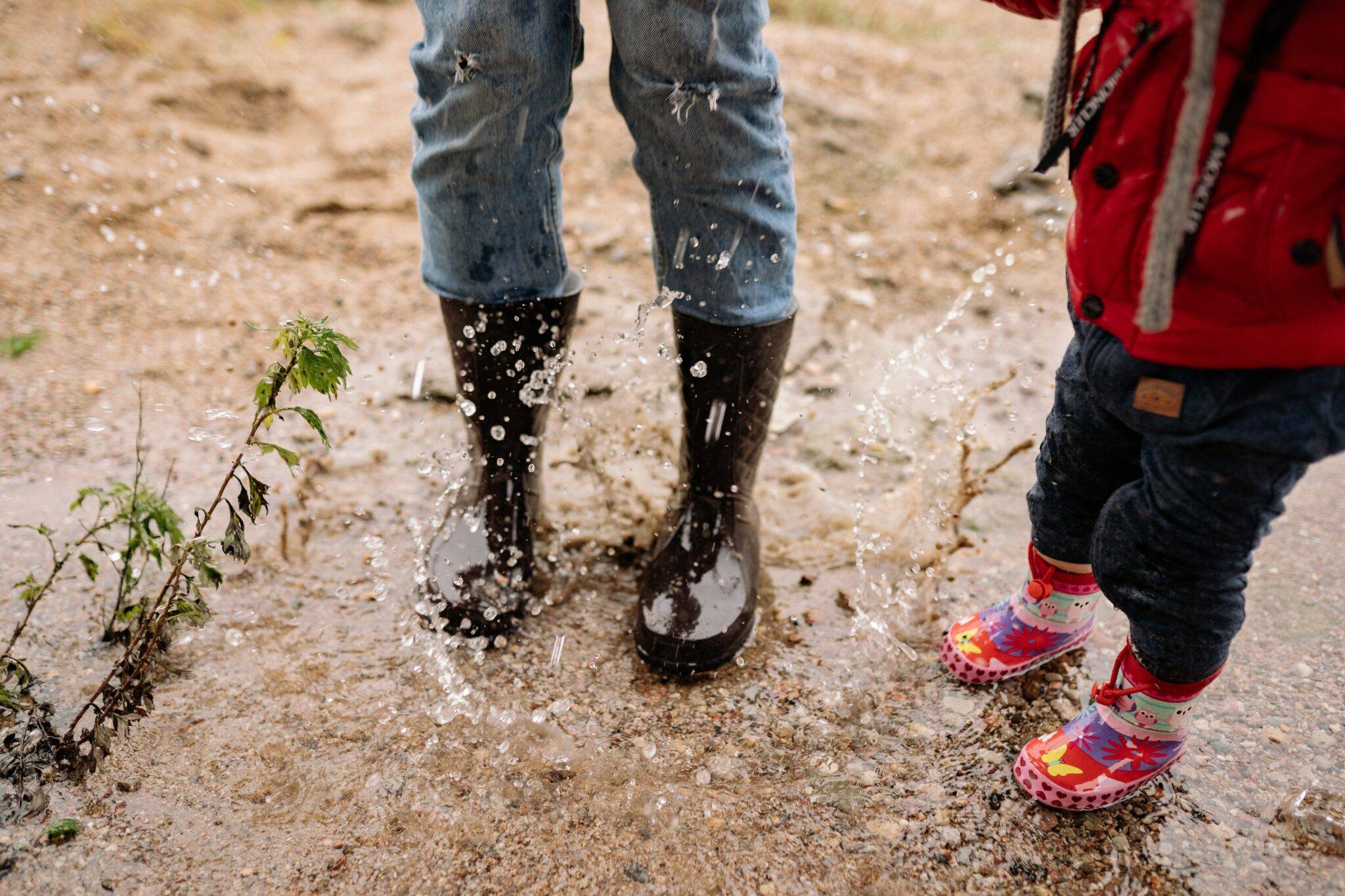 A mother and child standing in a puddle of water.