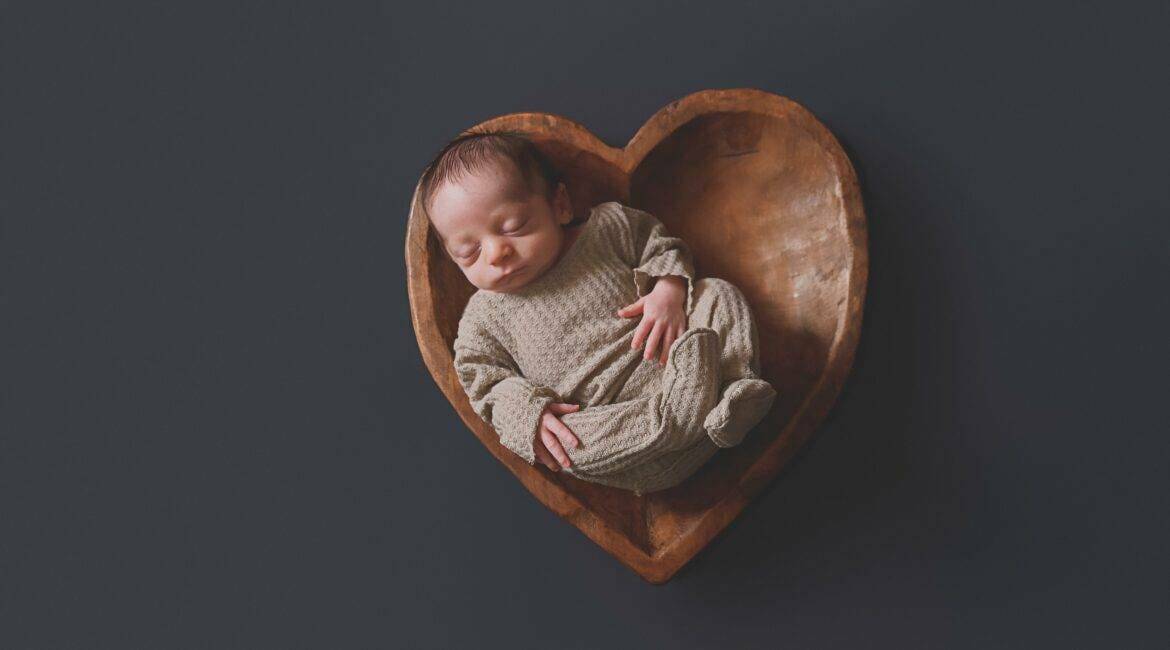 newborn in a heart shaped bowl
