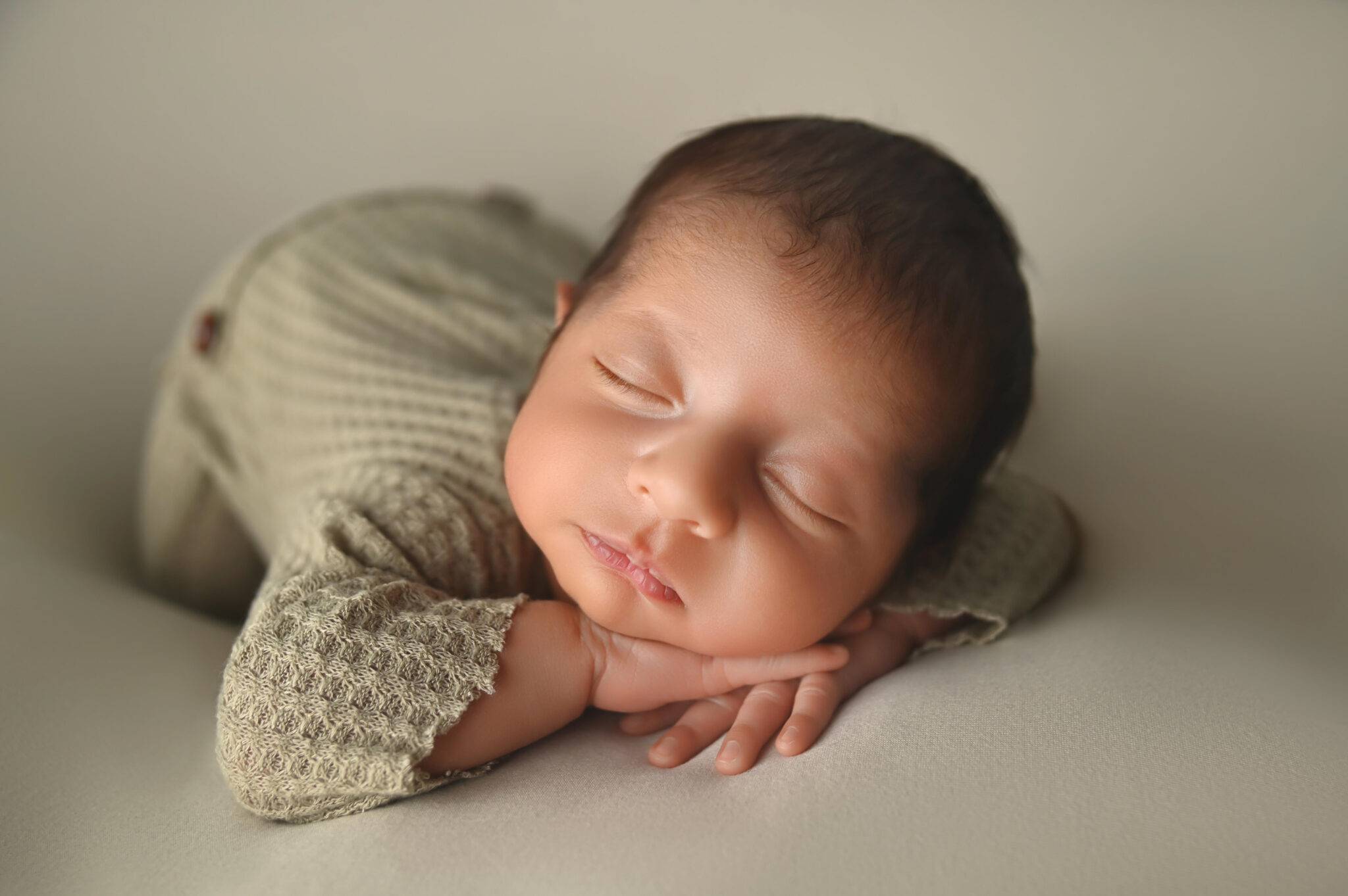 A newborn baby sleeping on a white background.