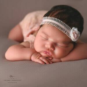 newborn baby girl with head on hands, posing in studio