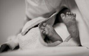 A black and white photo of a baby's feet.