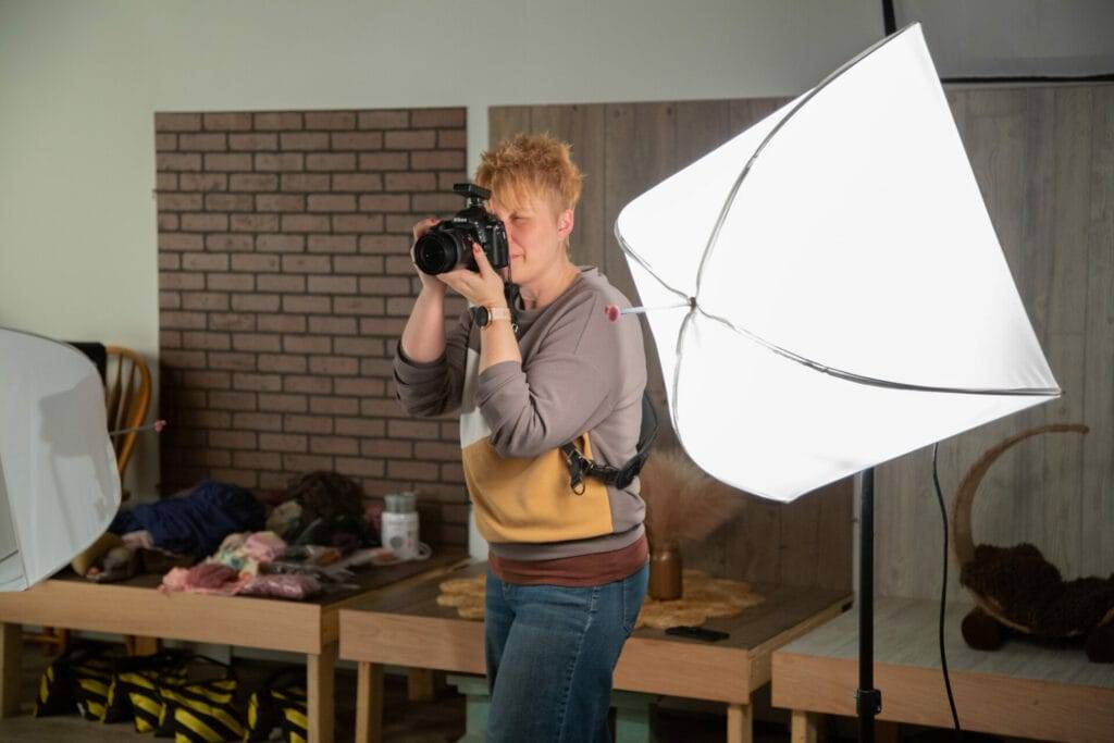 A woman participating in a Photography Mentorship program, holding a camera.