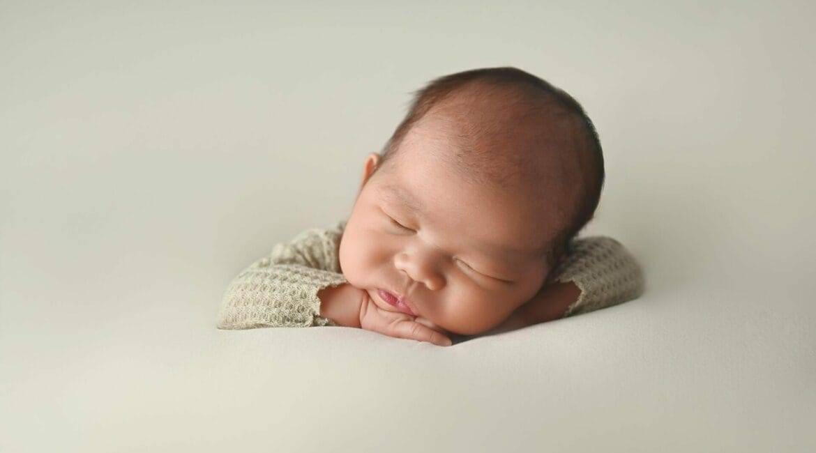 Newborn baby sleeping peacefully on a soft surface.