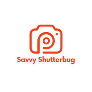 A red stylized camera logo with the text "Savvy Shutterbug" below it, perfect for those passionate about photography education. The circular design in the center resembles a camera lens on a clean white background, reflecting a commitment to nurturing photography mentorships.