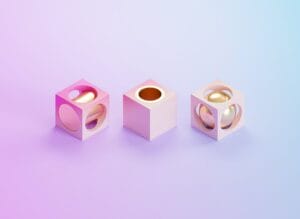 Three abstract pink cubes with circular cutouts; two with golden spheres inside, one empty. Background is a gradient of purple to blue.