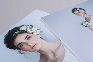 Two photographs of a woman with a floral headpiece and bouquet. One image is a close-up, and the other shows her upper body. Both photos are on a light-colored surface.