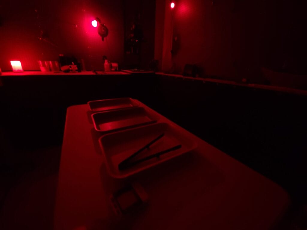 Red safelight glow inside a darkroom at Giliane's Saint Paul studio