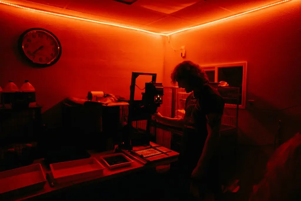 Photographer at an enlarger making darkroom prints — the Saint Paul Darkroom opens November 1st