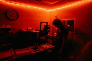 Photographer at an enlarger making darkroom prints — the Saint Paul Darkroom opens November 1st