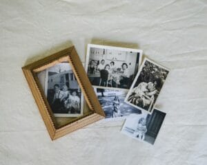 Overhead view of old black and white family photographs spread out on a surface