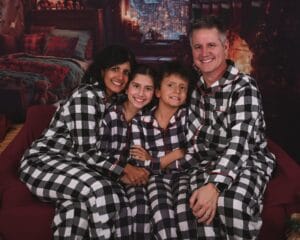 Family in matching plaid pajamas for a holiday card studio session