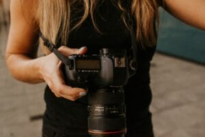 Woman photographer holding a DSLR camera during a one-on-one mentoring session
