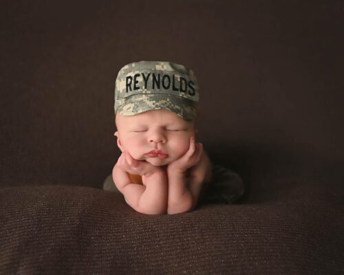 A baby wearing a hat with the word reynolds on it.