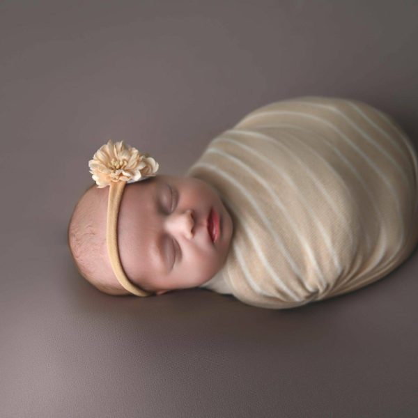 00001_Jtwins_002 a baby sleeping on a blanket on a grey surface.