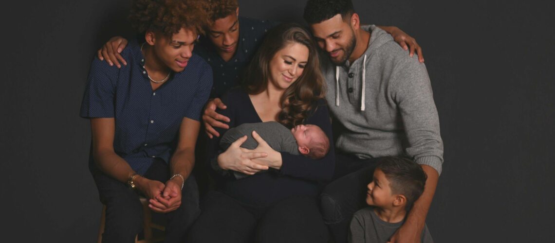 A group of people posing for a photo with a baby in their arms.