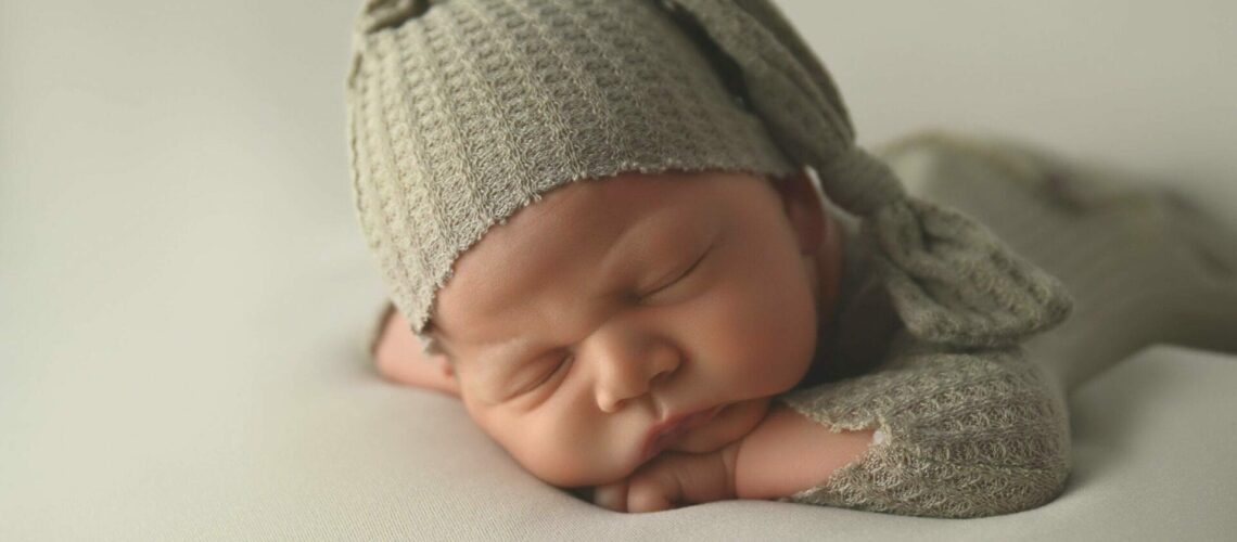 A baby sleeping in a knit hat.