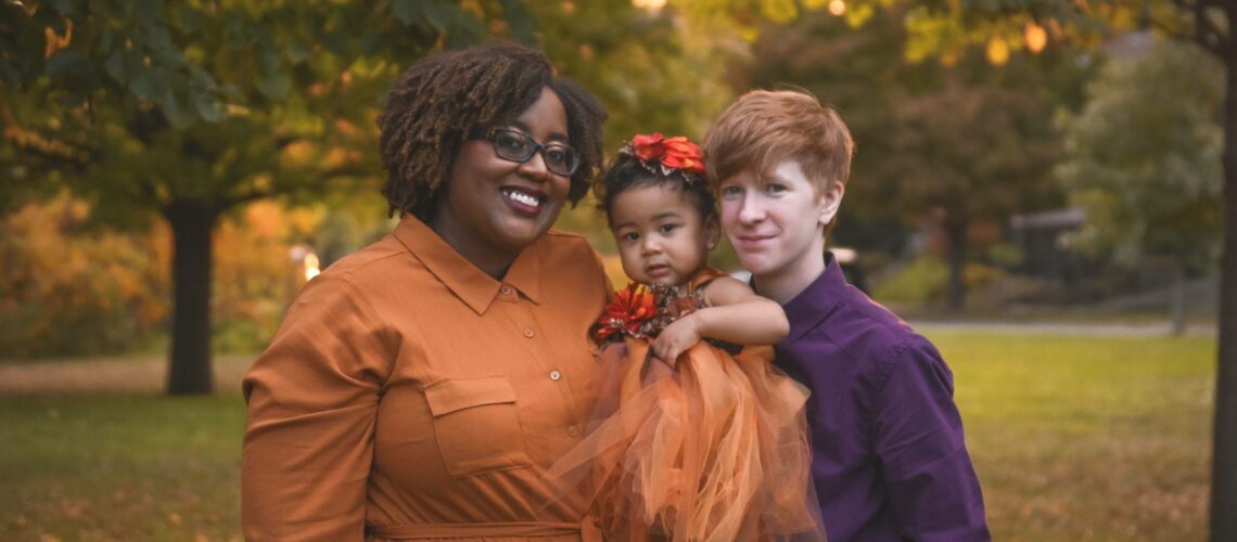A family poses for an autumn photo in a park in Saint Paul.
