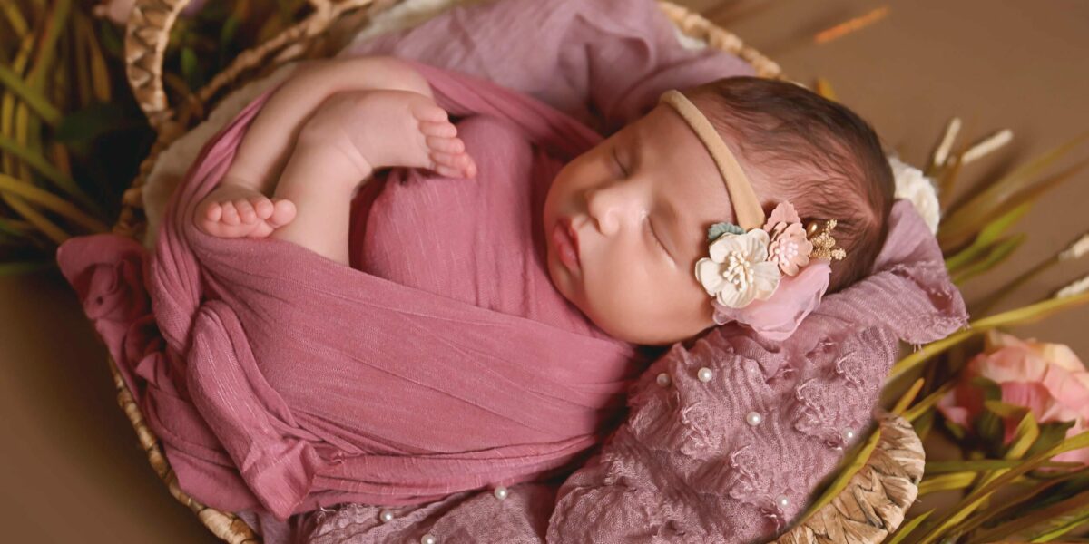 A baby sleeping in a basket.