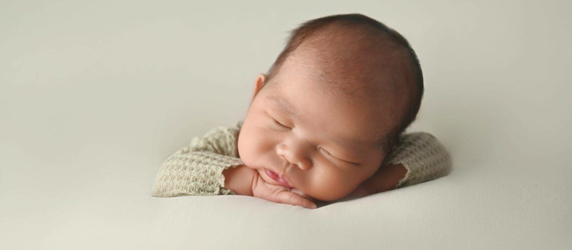 Newborn baby sleeping peacefully on a soft surface.