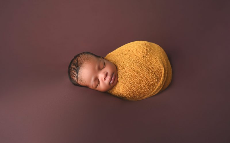 newborn in a wrap posed at Giliane E Mansfeldt Photography Studios