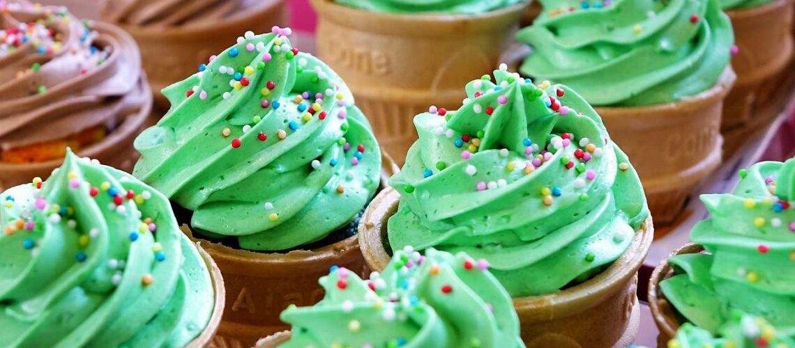 Ice cream cones with green frosting and sprinkles.