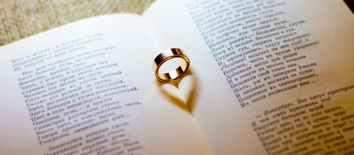 A ring sits on top of an open book.