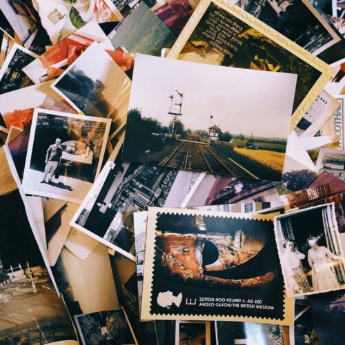 A pile of assorted vintage photographs and postcards, some in color and some in black and white, scattered and overlapping each other.